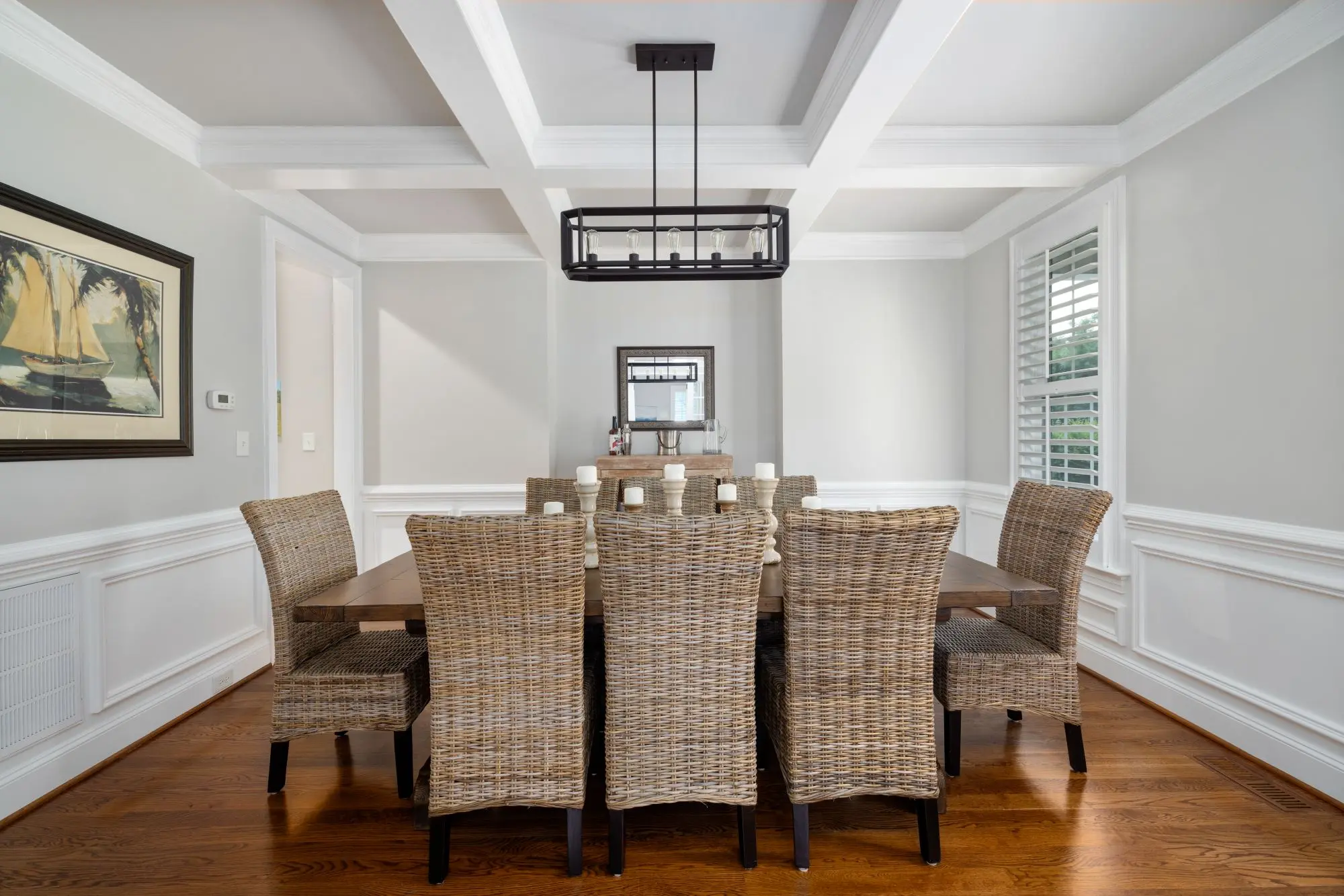 Dining room with wicker chairs under a coffered ceiling