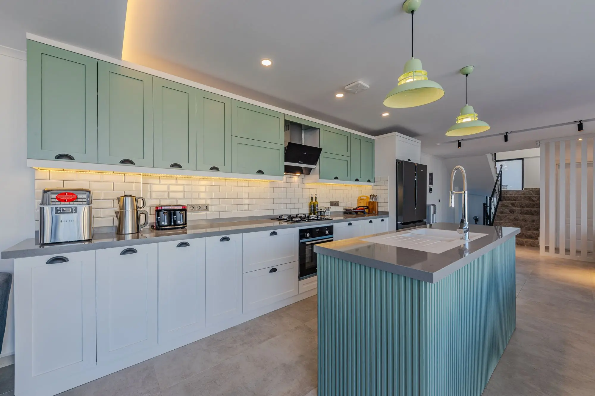 Kitchen with cabinets painted sage green and white counters