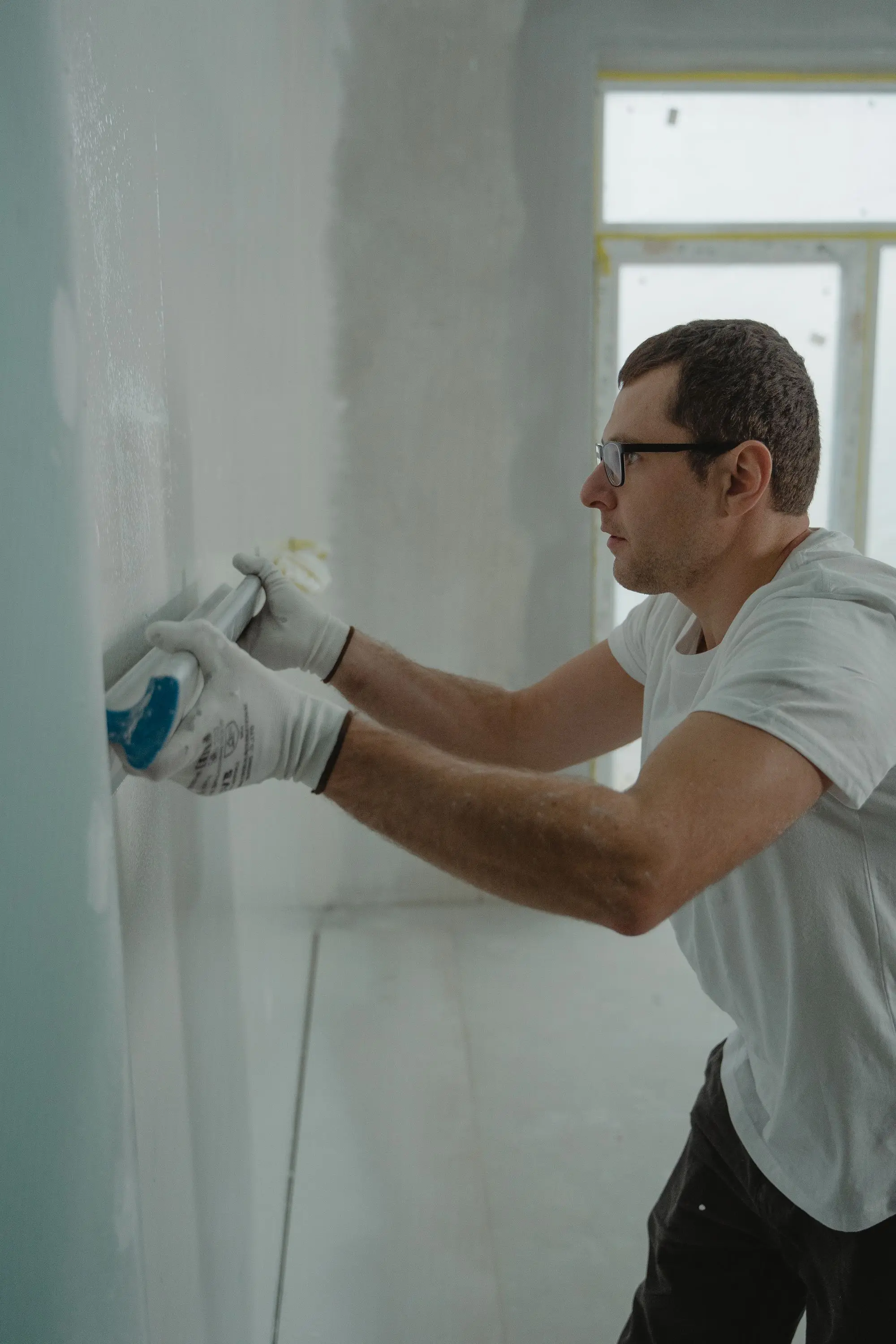 Worker applying drywall compound during a renovation