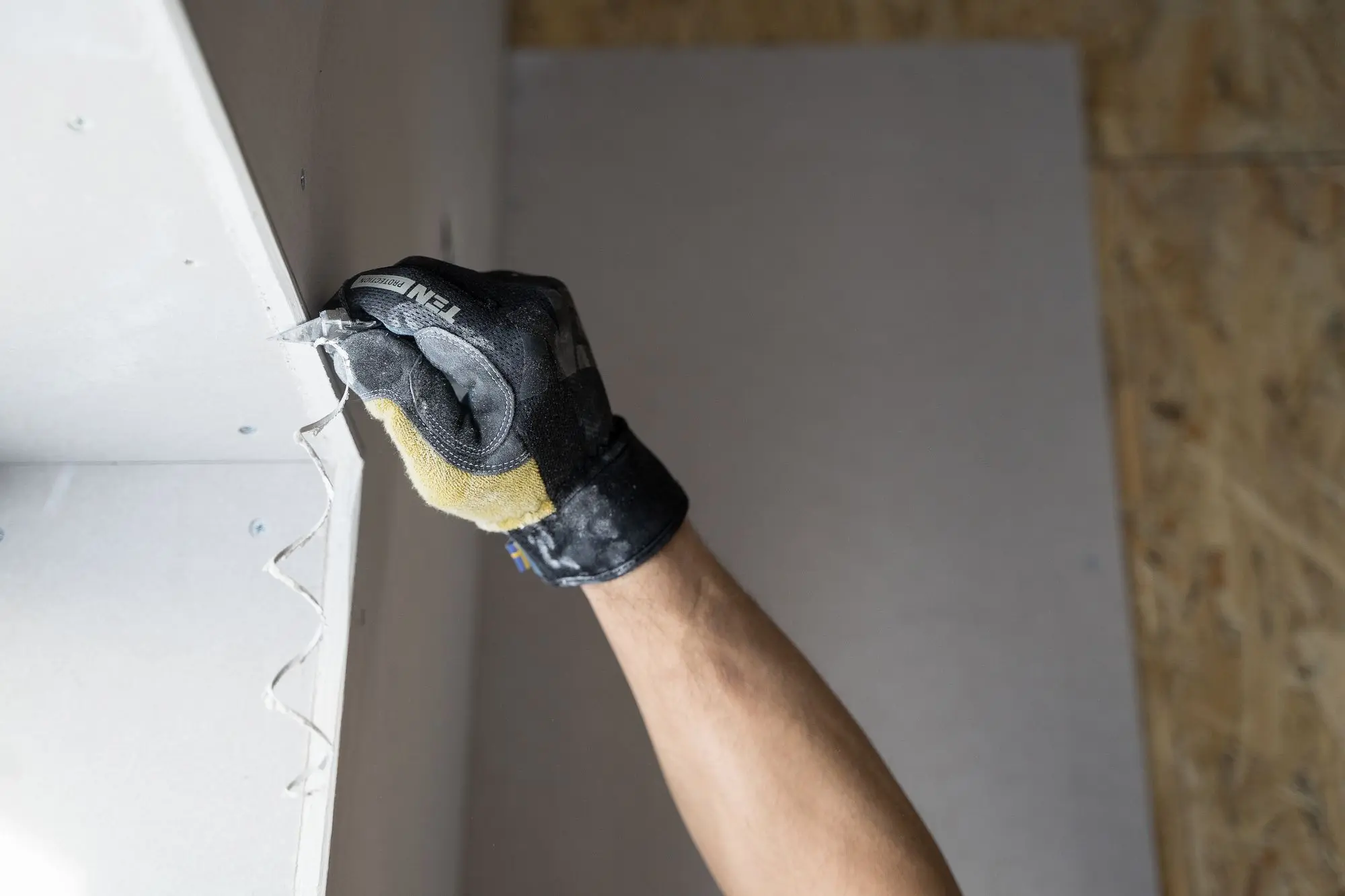 Gloved hand skimming a wall patch smooth