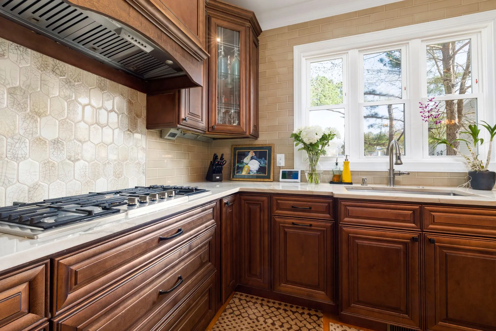 Handmade tile backsplash behind a range with wood cabinets