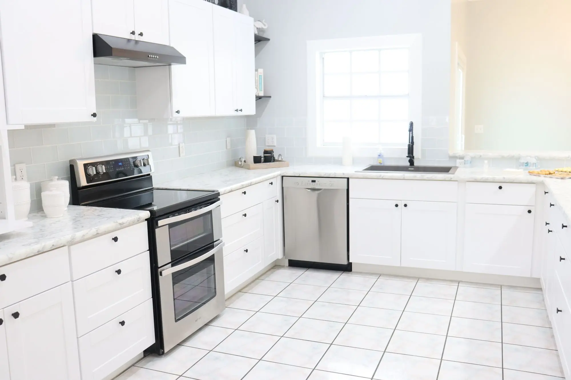 Bright kitchen with white shaker cabinets and stainless appliances
