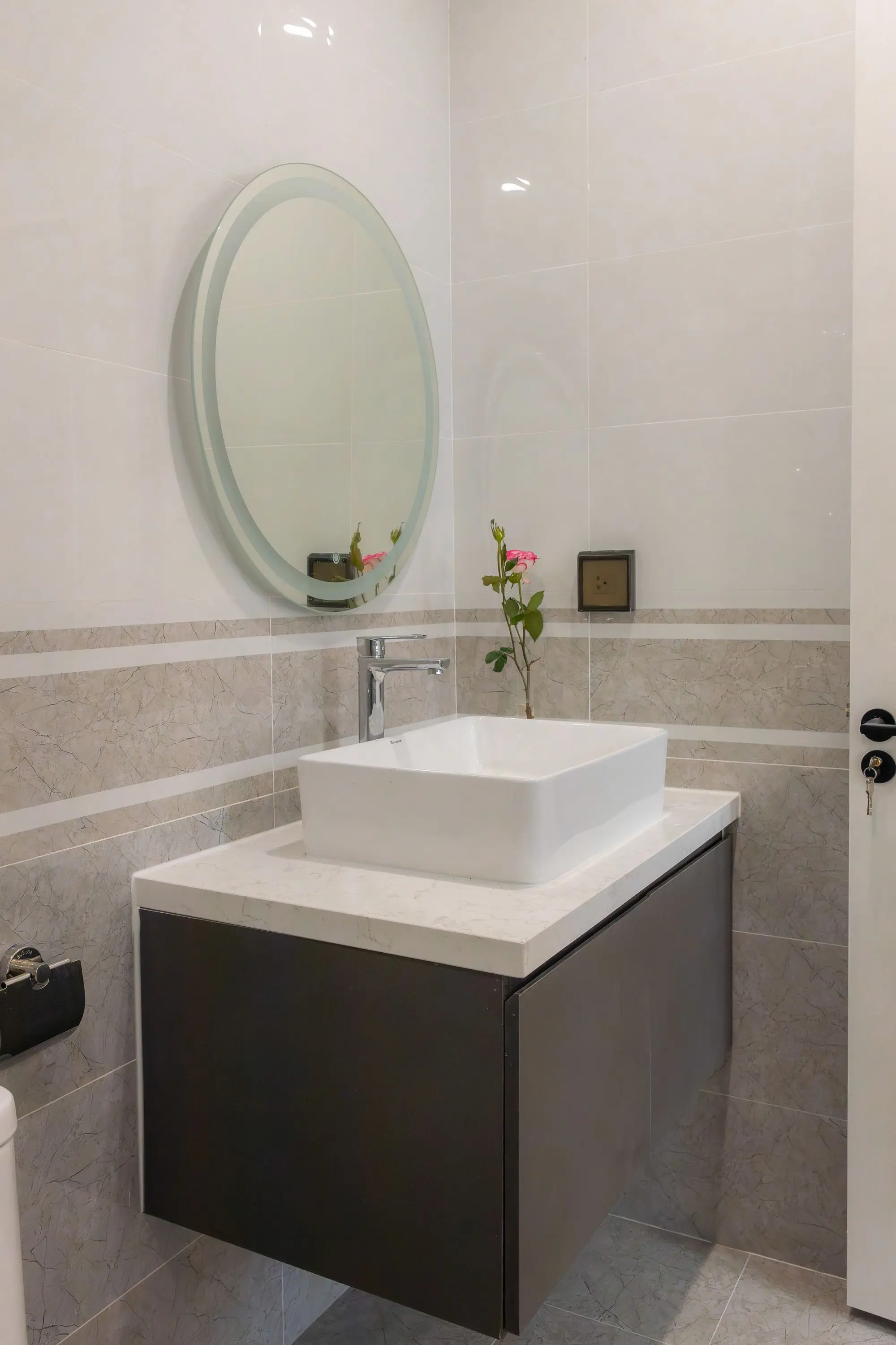 Small bathroom with a floating walnut vanity and round mirror