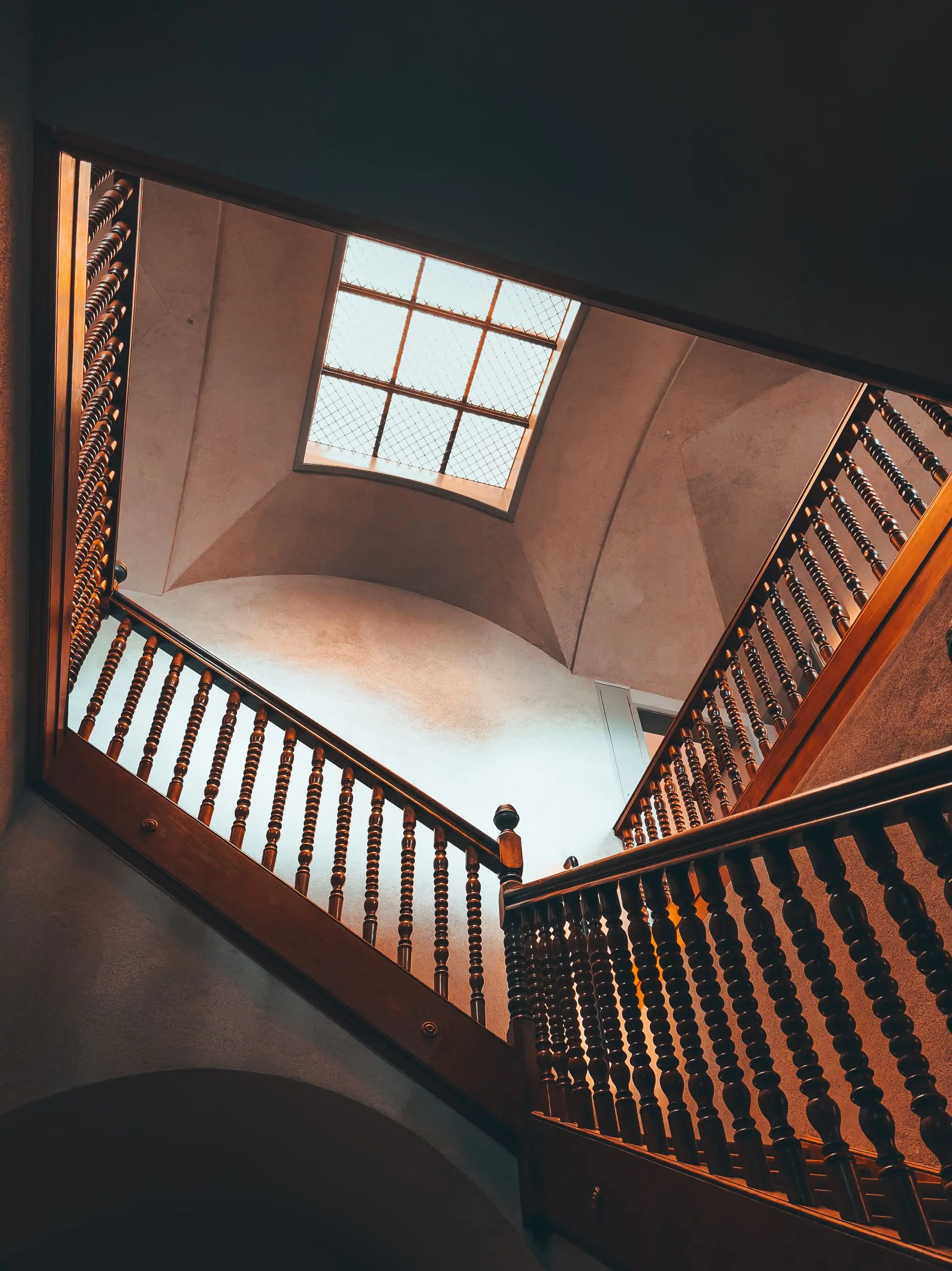 Looking up a wooden staircase with a turned balustrade