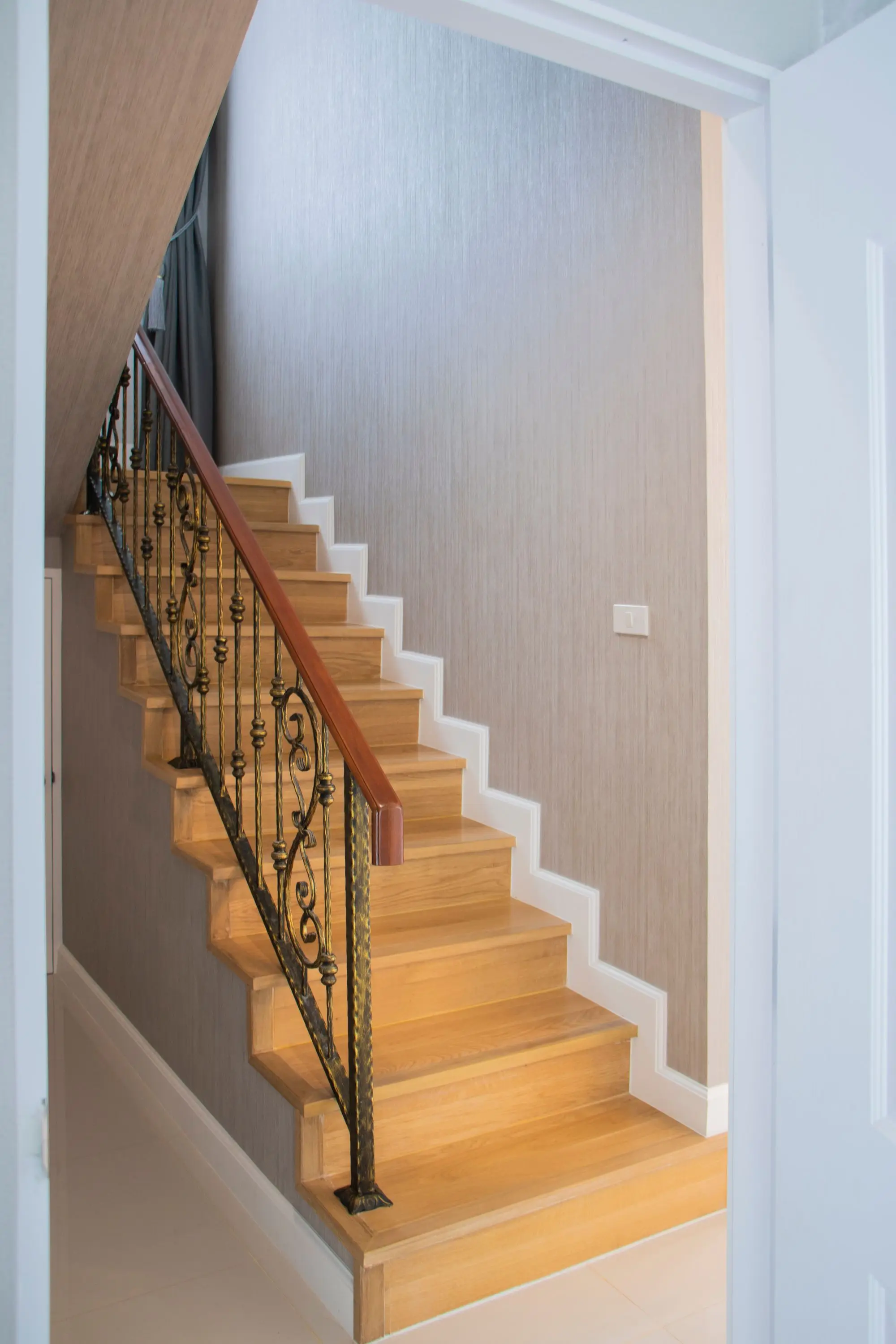 Staircase with oak treads, white risers and an iron railing