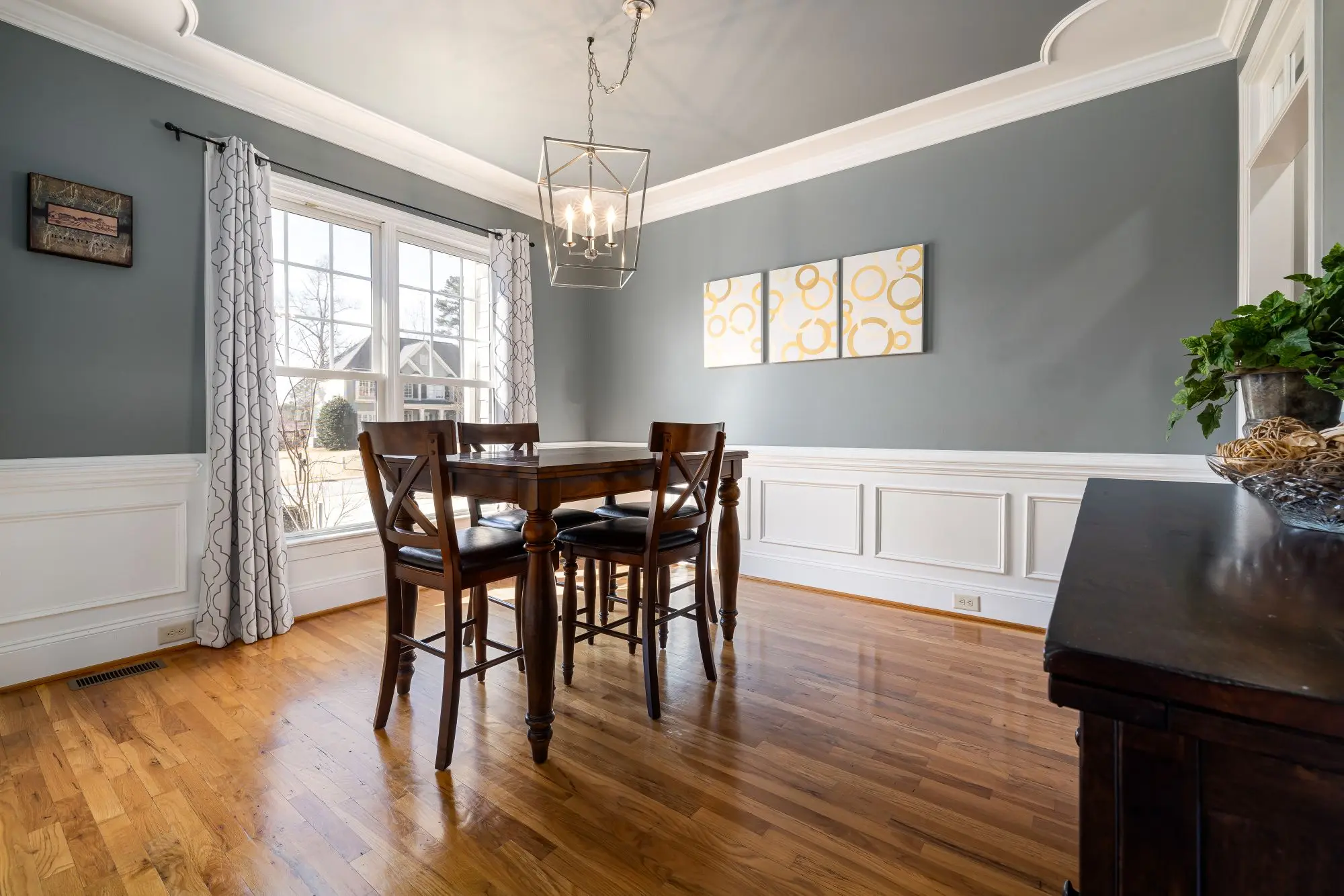 Dining room with picture-frame wainscoting and a bay window