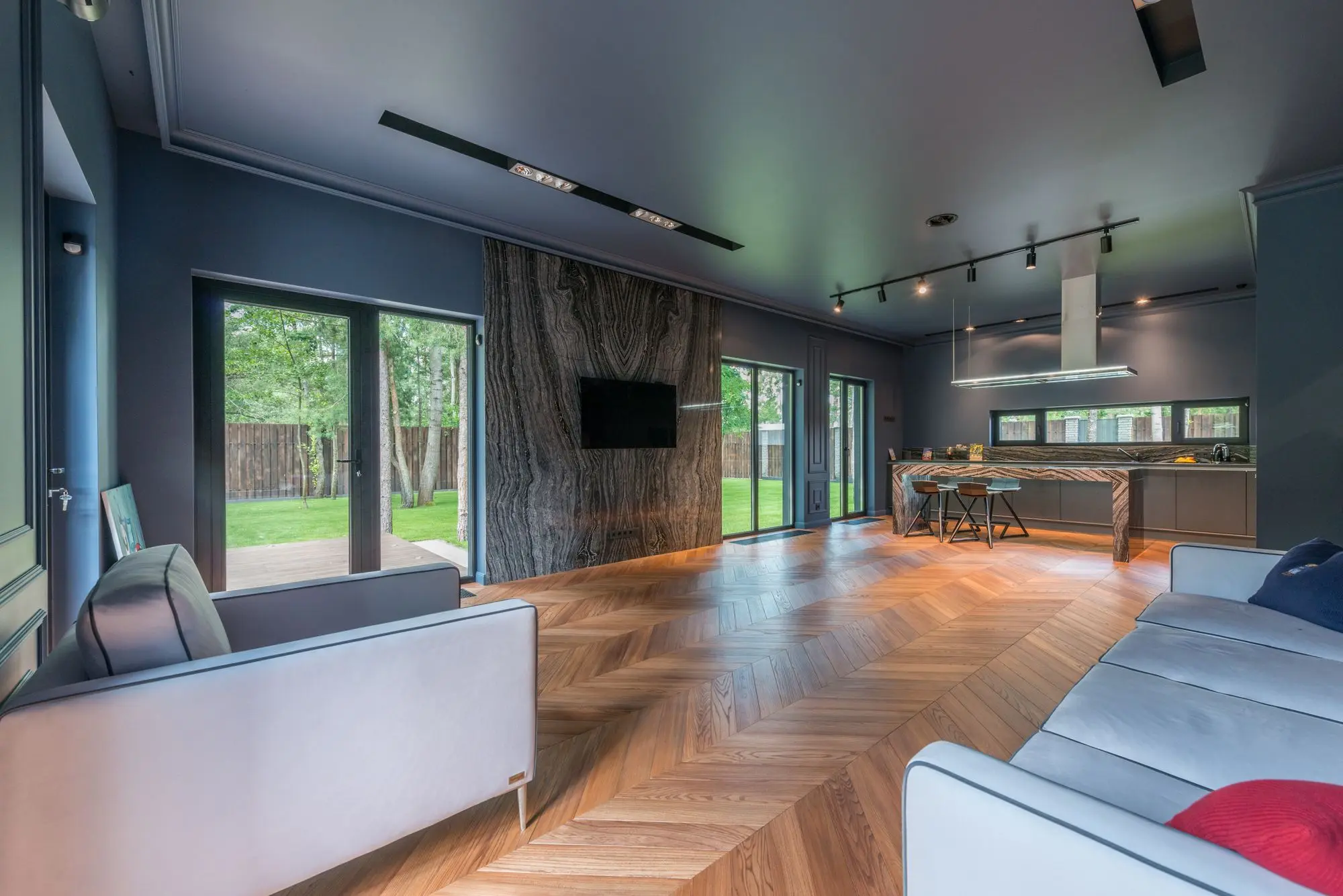 Open plan living room with wide-plank floors and full height windows