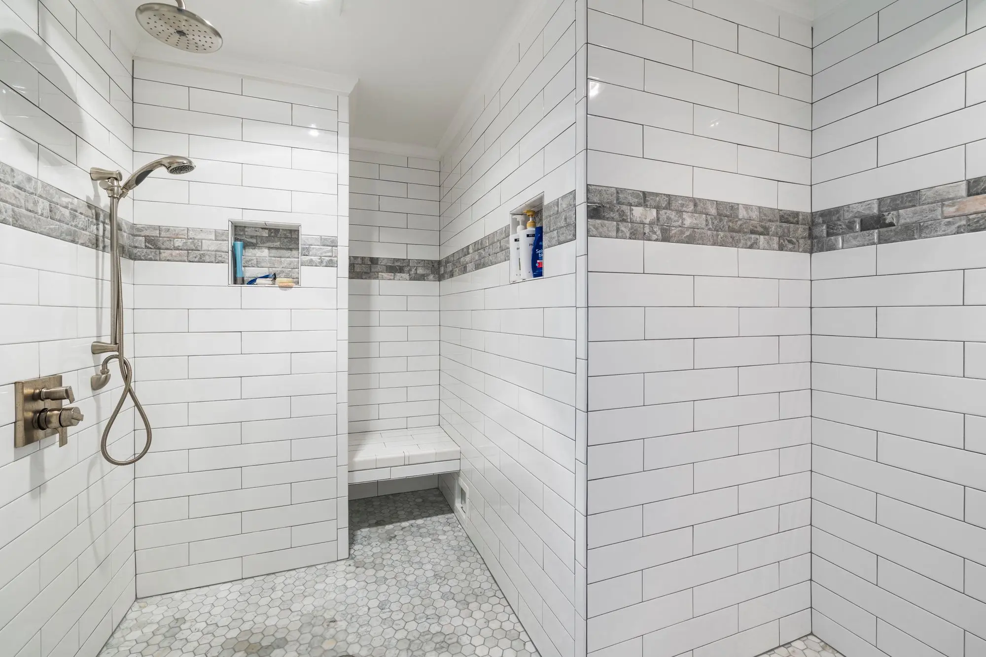 White subway tiled walk-in shower with a black-framed glass door